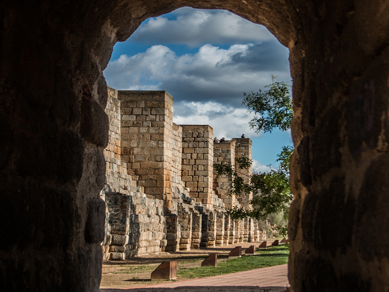 Muur van het Alcazaba in Mérida vanonder een boog van de Romeinse brug